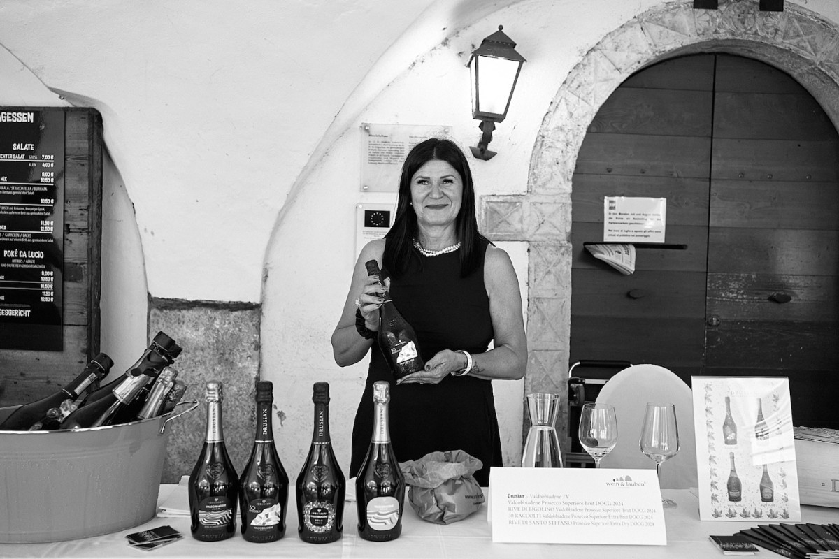 Eine Vertreterin von Drusian präsentiert eine Flasche Schaumwein.