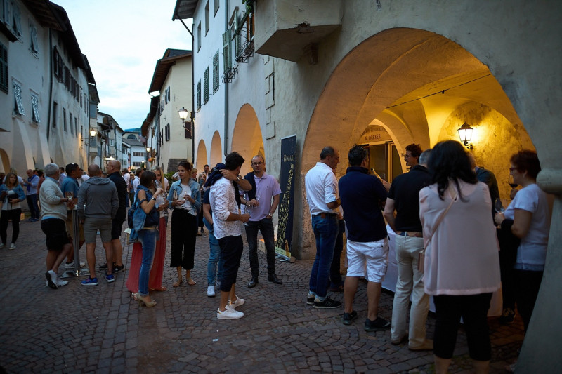 People standing in the passage of the WIne & Arcades event in the dusk