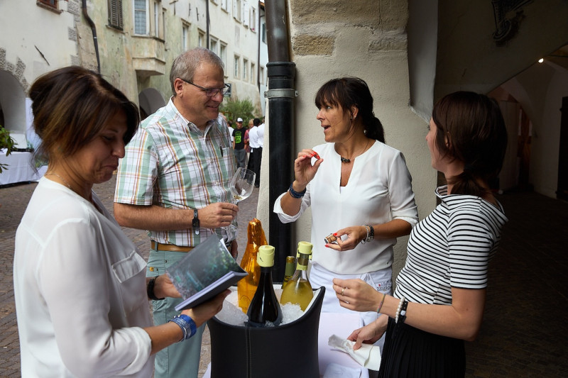 A photo of people discussing the wine they are tasting at the Wine & Arcades event