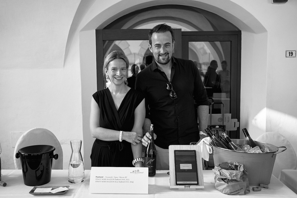 Zwei Vertreter zeigen eine Weinflasche.