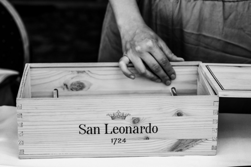 Photo of a person opening a wooden winebox at the Wine and Arcades event